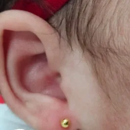 Orelha de bebê com brinco de bolinha dourada em titânio