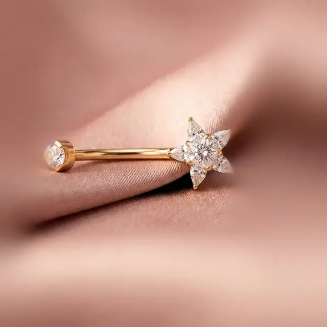 Piercing dourado com flor de cristais sobre cetim rosé
